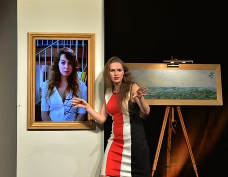 Une actrice sur scène devant des tableaux