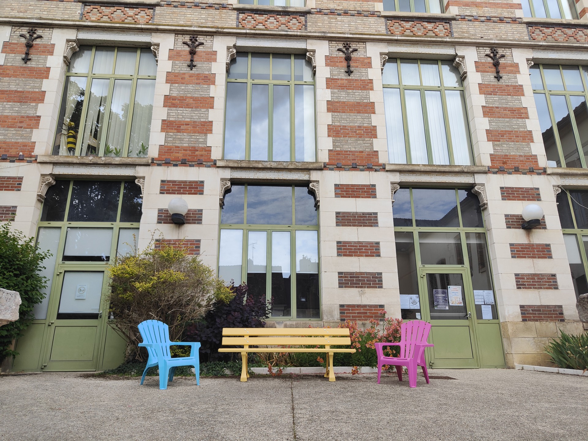 Un banc jaune installé devant le conservatoire