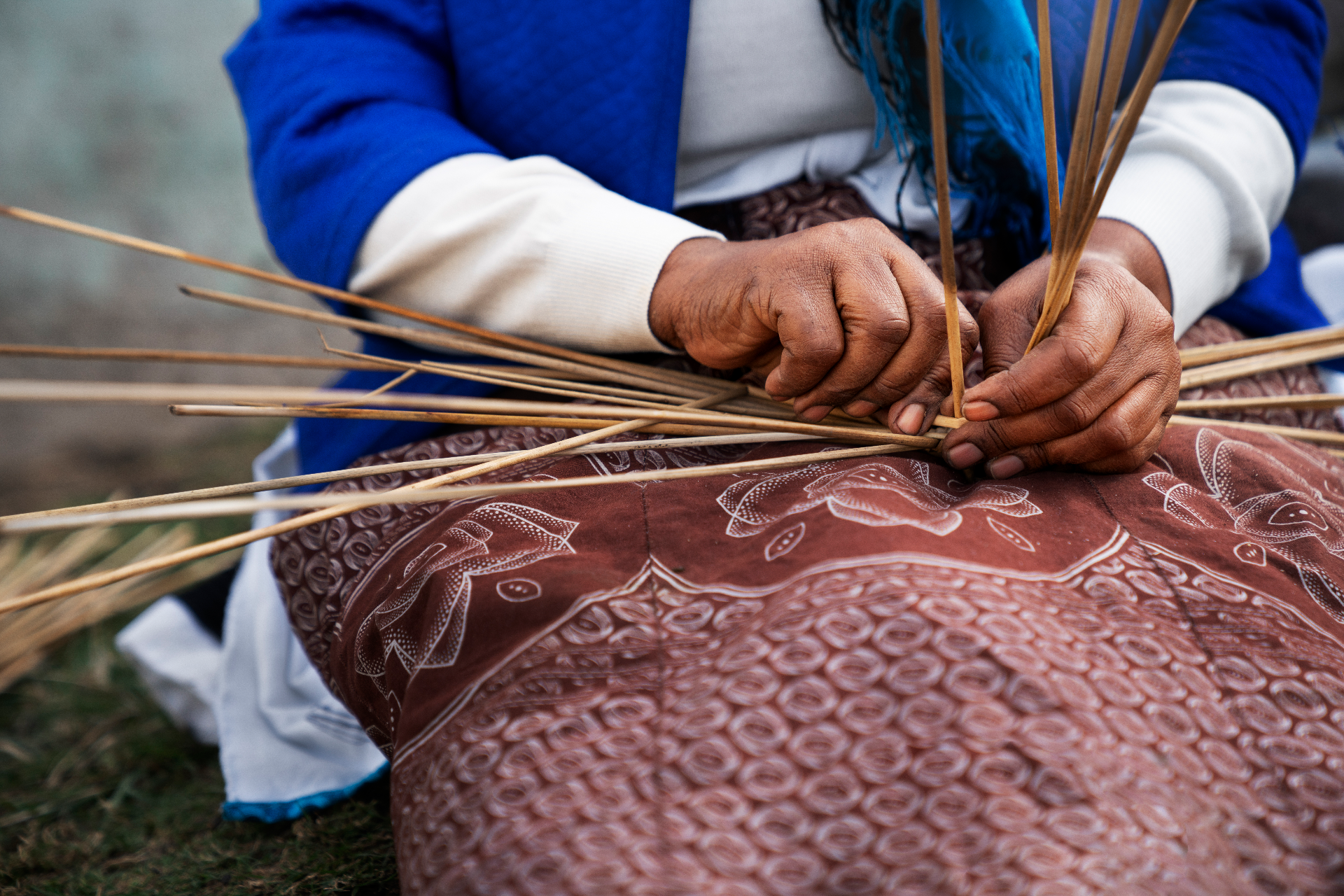Une femme en train de fabriquer un objet en paille