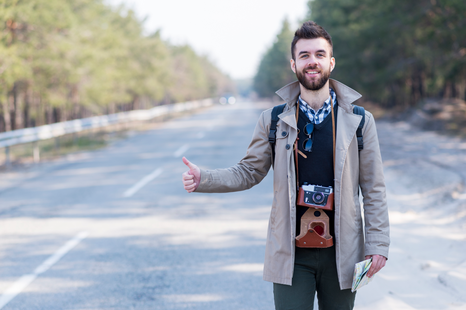 Un jeune touriste qui fait du stop le long d'une route