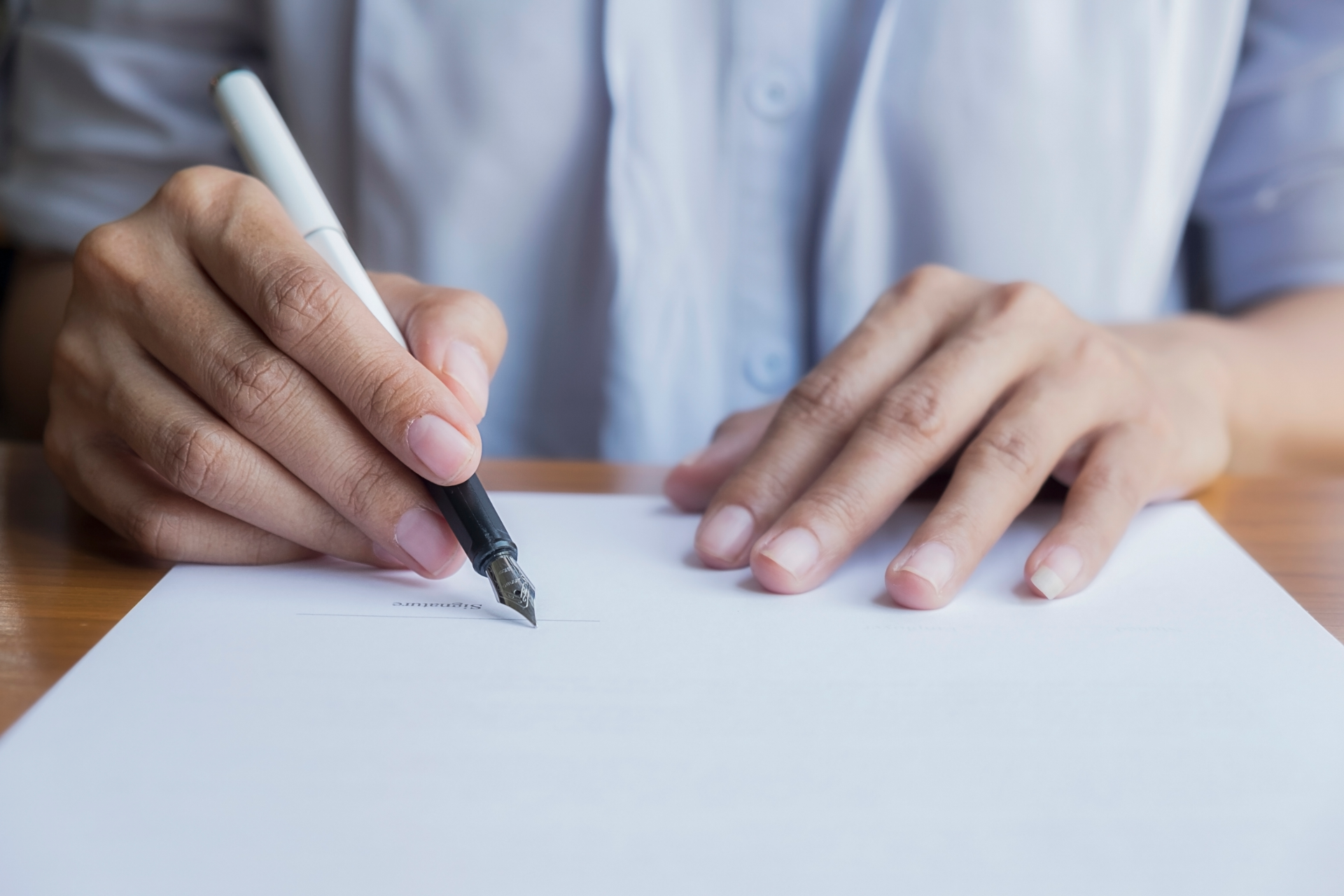 Une femme qui s'apprête à signe un document