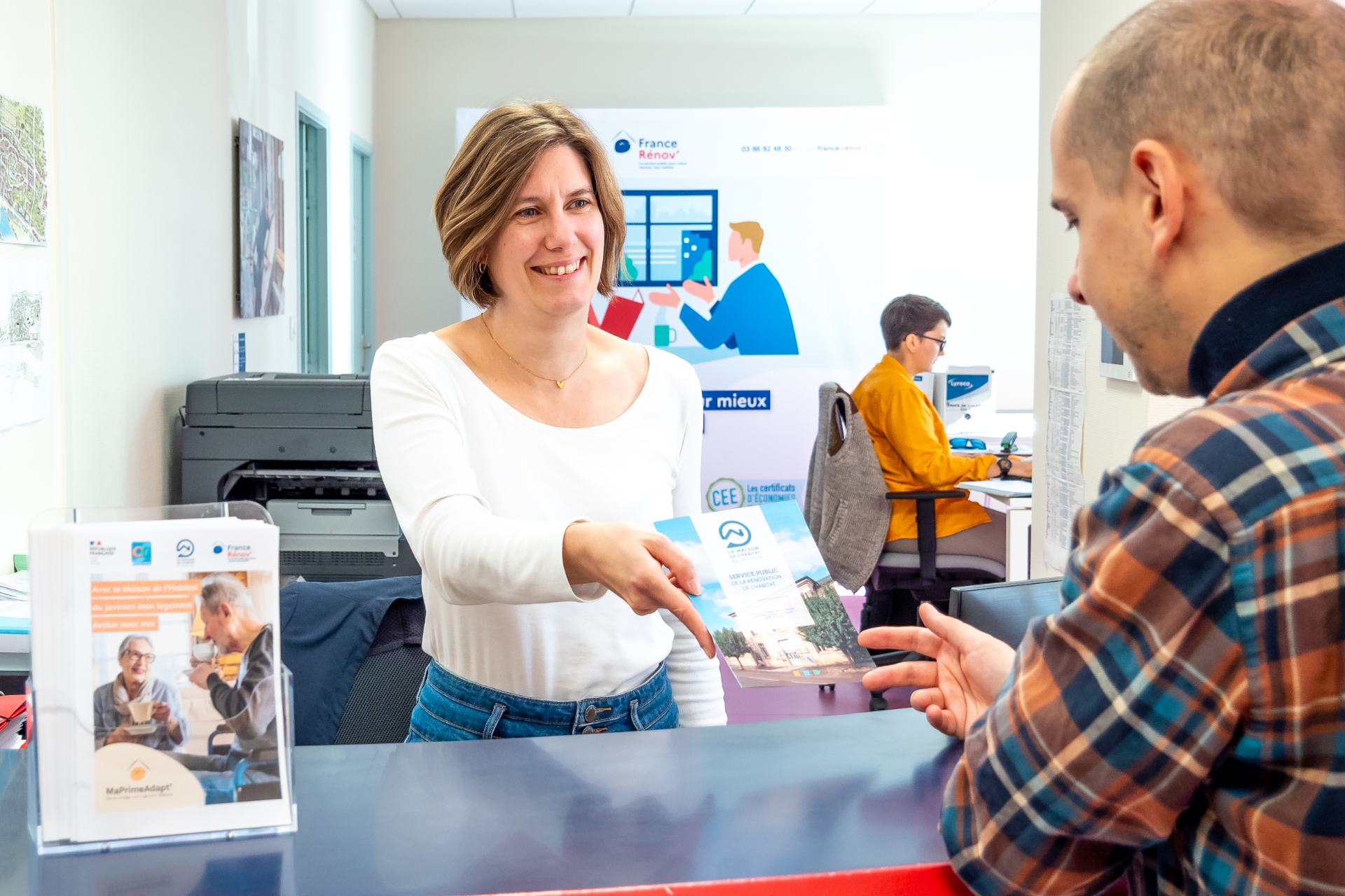 Une conseillère qui tend un document à un visiteur